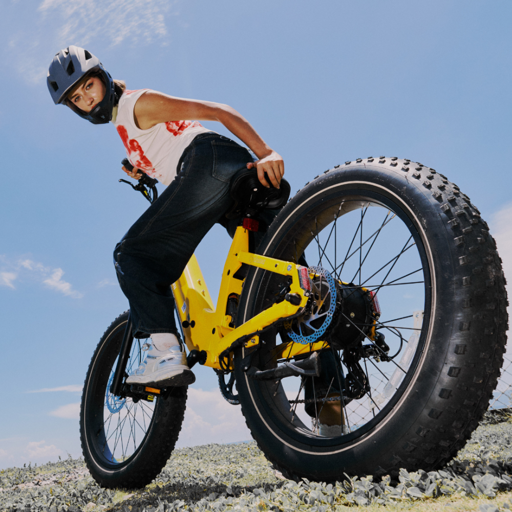 Low-angle view of a rider on the yellow Roma and its 26-inch fat tire