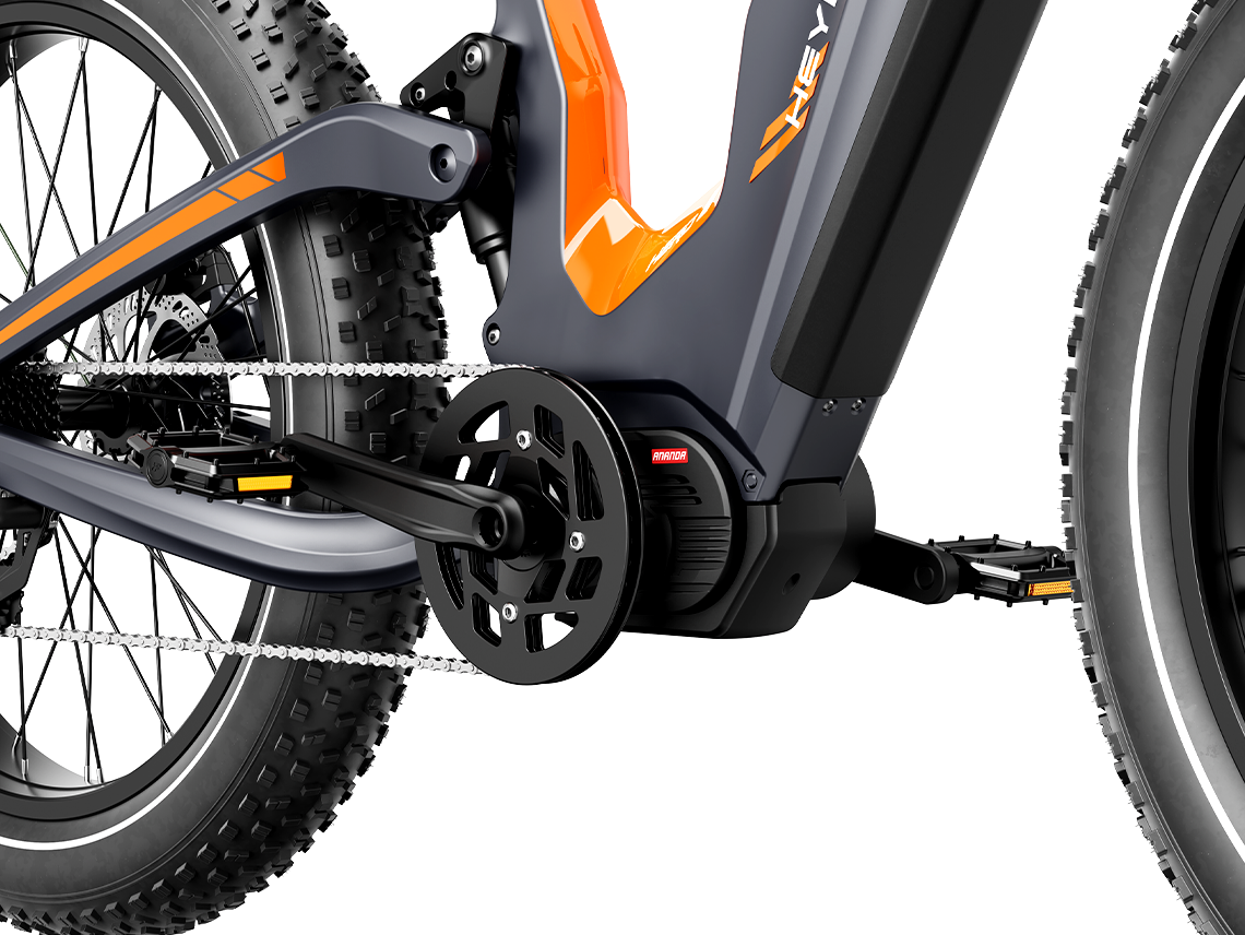 Close-up of the Heybike Hero mid-drive motor mounted at the bottom bracket, showing the torque sensor, the crank arm, the chainring, and the chain routing into the rear derailleur