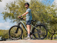 Helmeted rider standing beside a Macaron Green Velowave Swift M outdoors