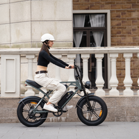 Helmeted rider passing a city building on the mint green bike