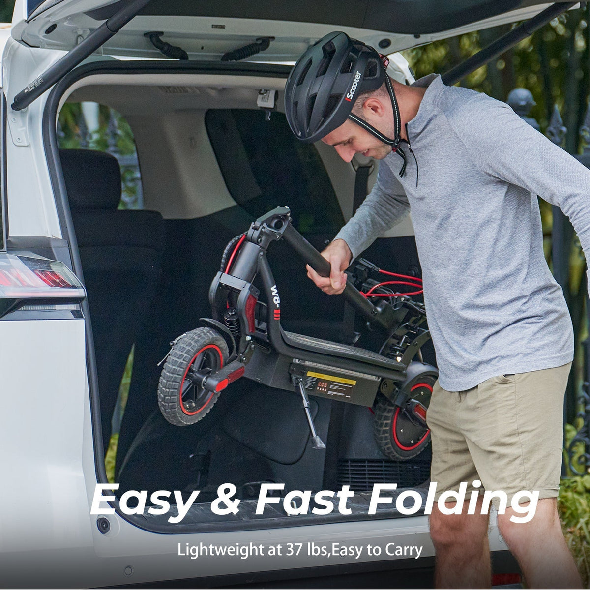Rider lifting the folded iScooter W8 into a car trunk to show storage and transport after folding.