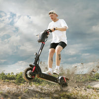 Helmeted rider standing on an isinwheel GT2 while crossing a rocky maintained path
