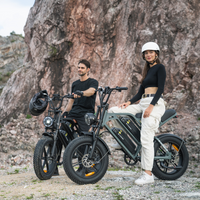 Two riders standing with their CycHunter bikes below a rocky cliff