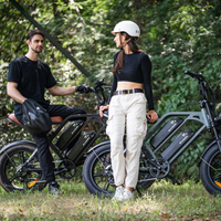 Man and woman standing beside black and mint green CycHunter bikes