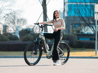 Rider standing beside a Light Green Velowave Breeze T on an urban street
