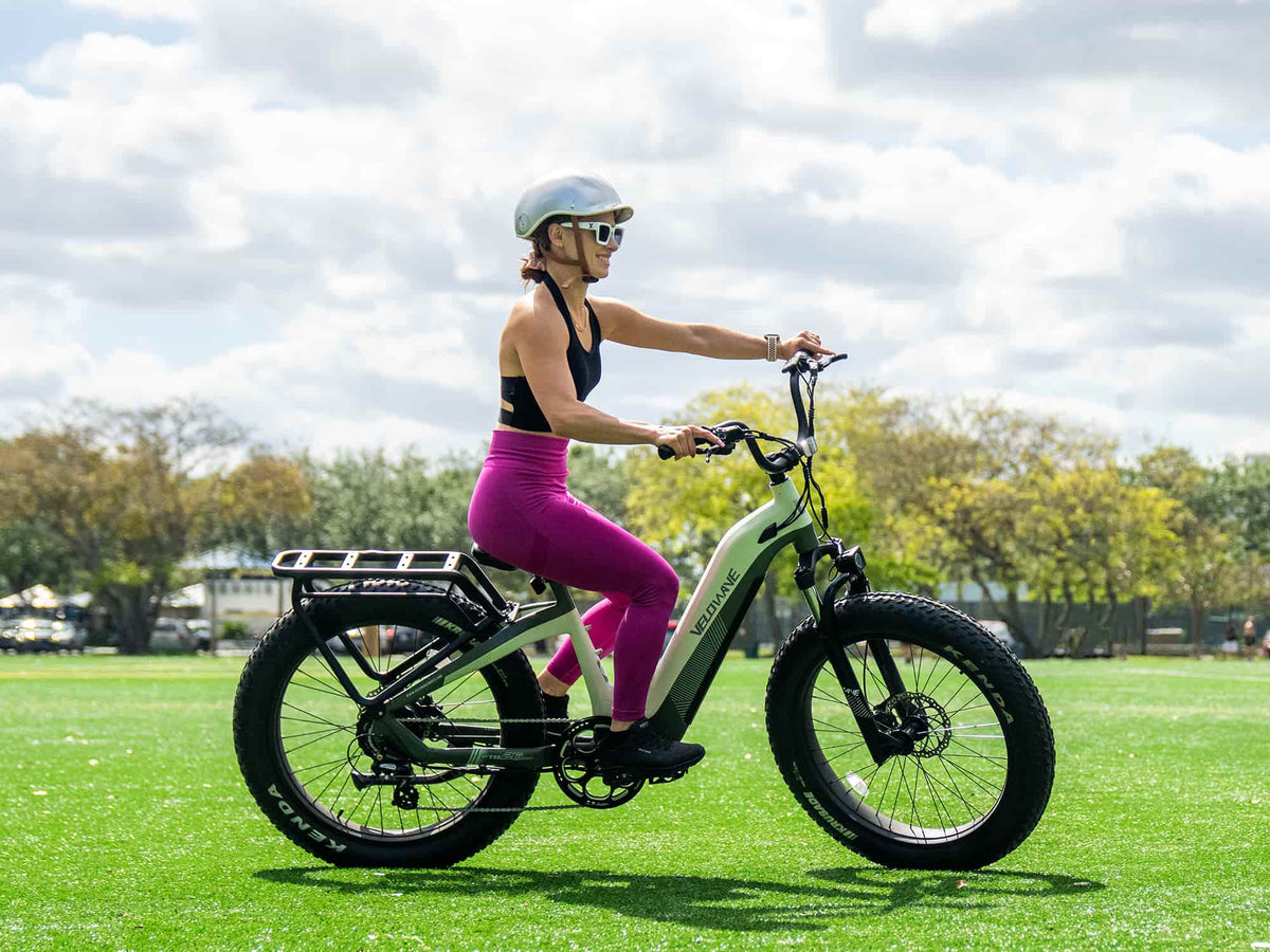 Rider on a Mint Green Velowave Grace 2.0 Step-Thru electric bike in a park