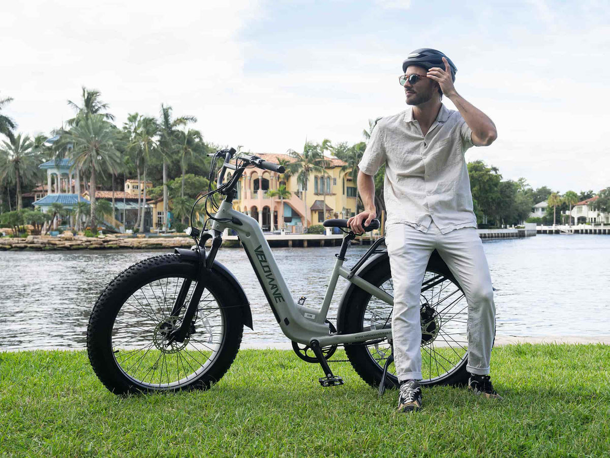 Rider beside a Velowave Ranger Step-Thru 2.0 electric bike at an urban fence