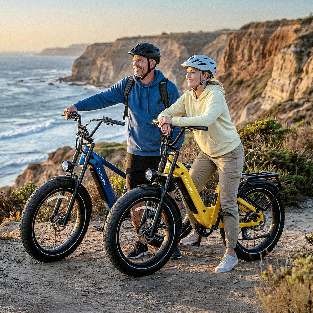 Two helmeted riders with blue and yellow Roma e-bikes on a coastal overlook