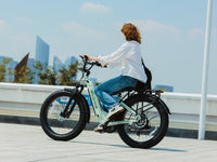 Rider on pale-green Velowave Ranger Step-Thru 3.0 in an urban plaza