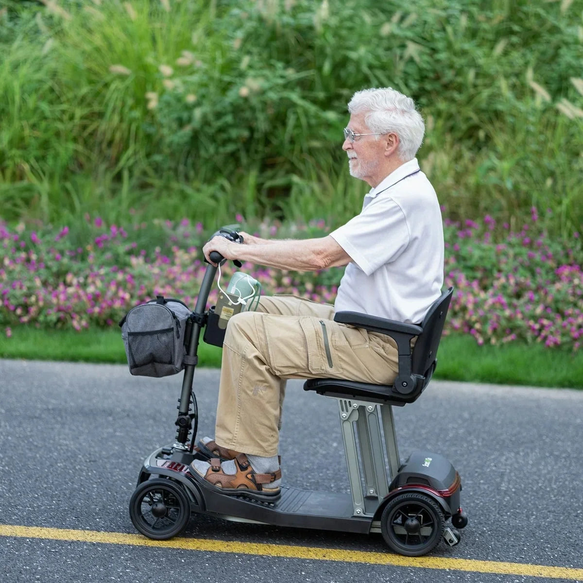 Adult riding a ScootNGo Folo mobility scooter on a paved path
