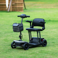 ScootNGo Folo four-wheel folding mobility scooter on a grassy lawn