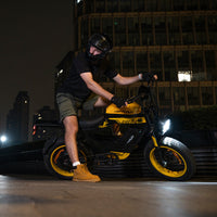 Front three-quarter studio view of the yellow HappyRun G100 Pro Tank with the matte black frame and yellow accents on the rims, headlight bracket, and tank graphics