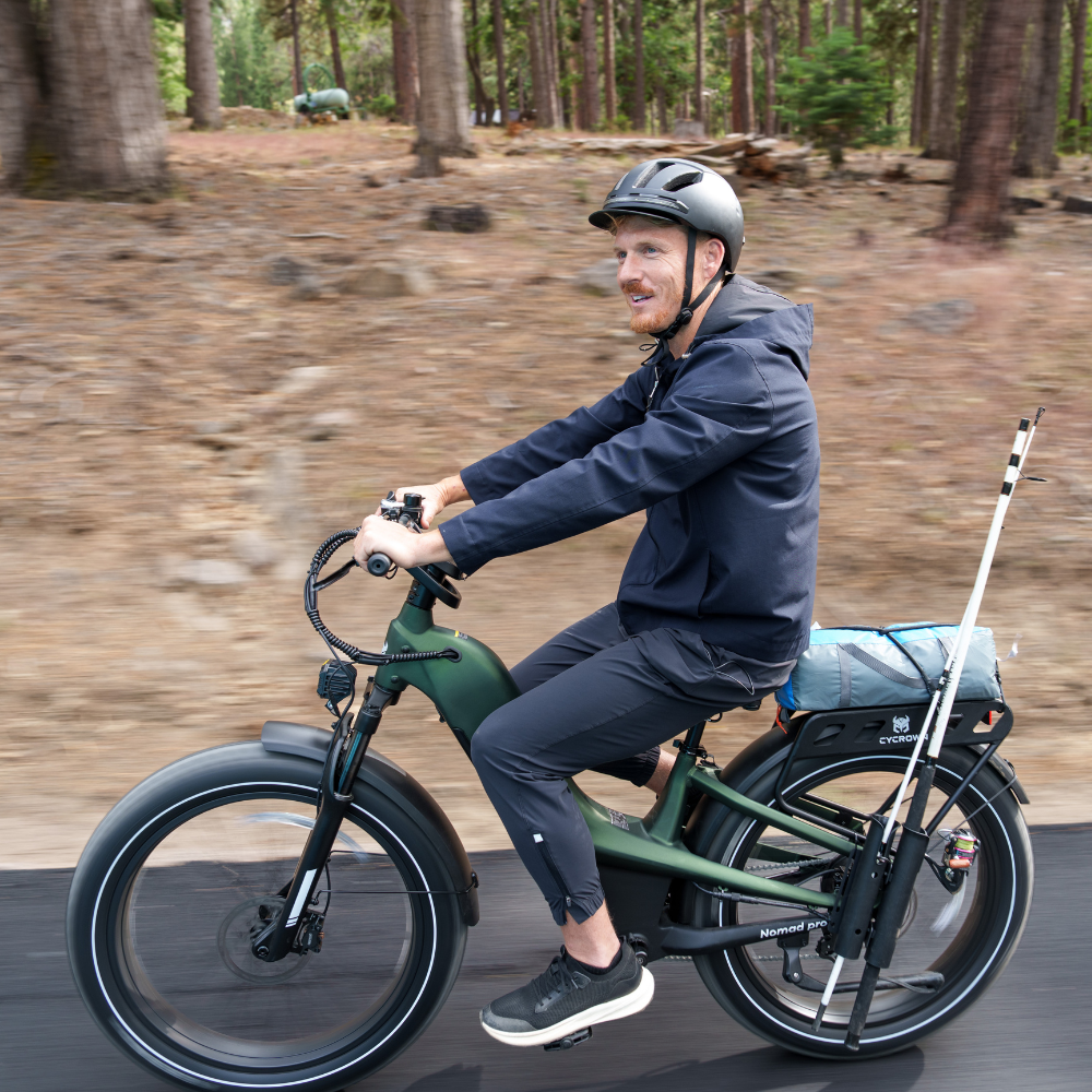 Rider taking the alpine green Nomad Pro through a forest path with a relaxed upright posture.
