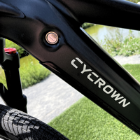 Cycrown logo and power button detail on the Dremax frame near the removable battery area.
