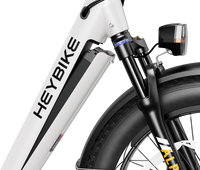 Heybike Alpha 500W mid-drive fat-tire all-terrain electric bike with a torque-plus-cadence sensor, Shimano Altus 8-speed drivetrain, hydraulic disc brakes, 26 by 4 inch fat tires, reinforced aluminum frame in step-through (Pearl White) or step-over (Galaxy Black) configuration, 680Wh battery, and UL 2849 certified electrical system