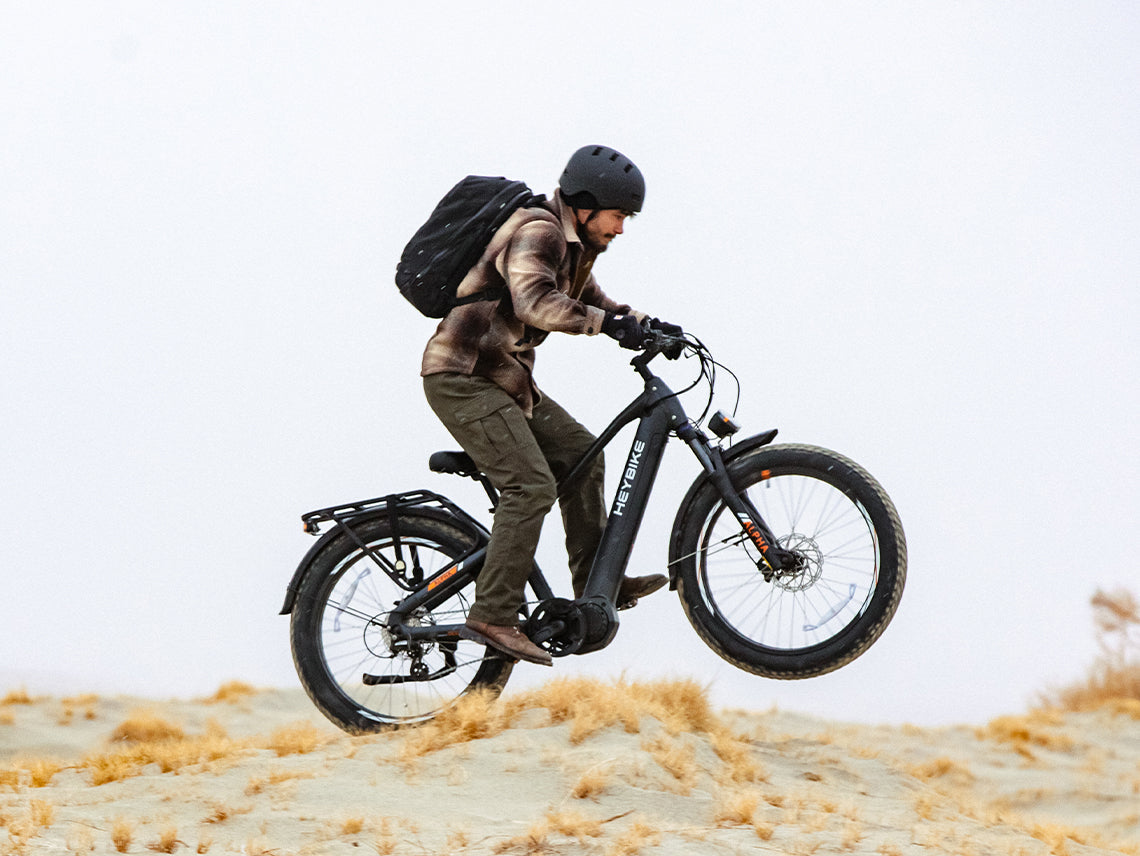 Heybike Alpha 500W mid-drive fat-tire all-terrain electric bike with a torque-plus-cadence sensor, Shimano Altus 8-speed drivetrain, hydraulic disc brakes, 26 by 4 inch fat tires, reinforced aluminum frame in step-through (Pearl White) or step-over (Galaxy Black) configuration, 680Wh battery, and UL 2849 certified electrical system