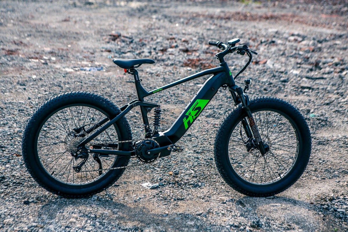 Black and green EUNORAU FAT-HS parked on a rocky track, showing its full-suspension frame