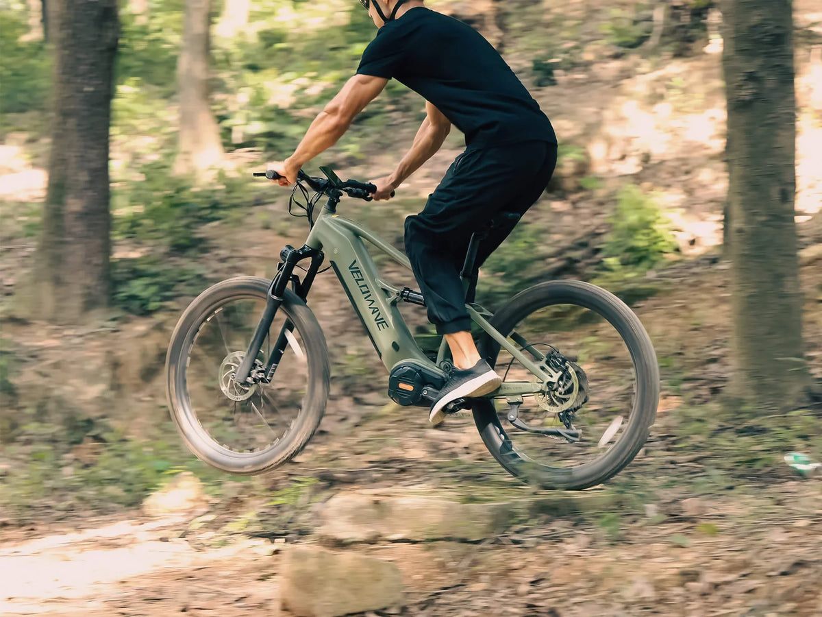 Velowave Forest XM Dark Green Forest XM riding over a trail obstacle