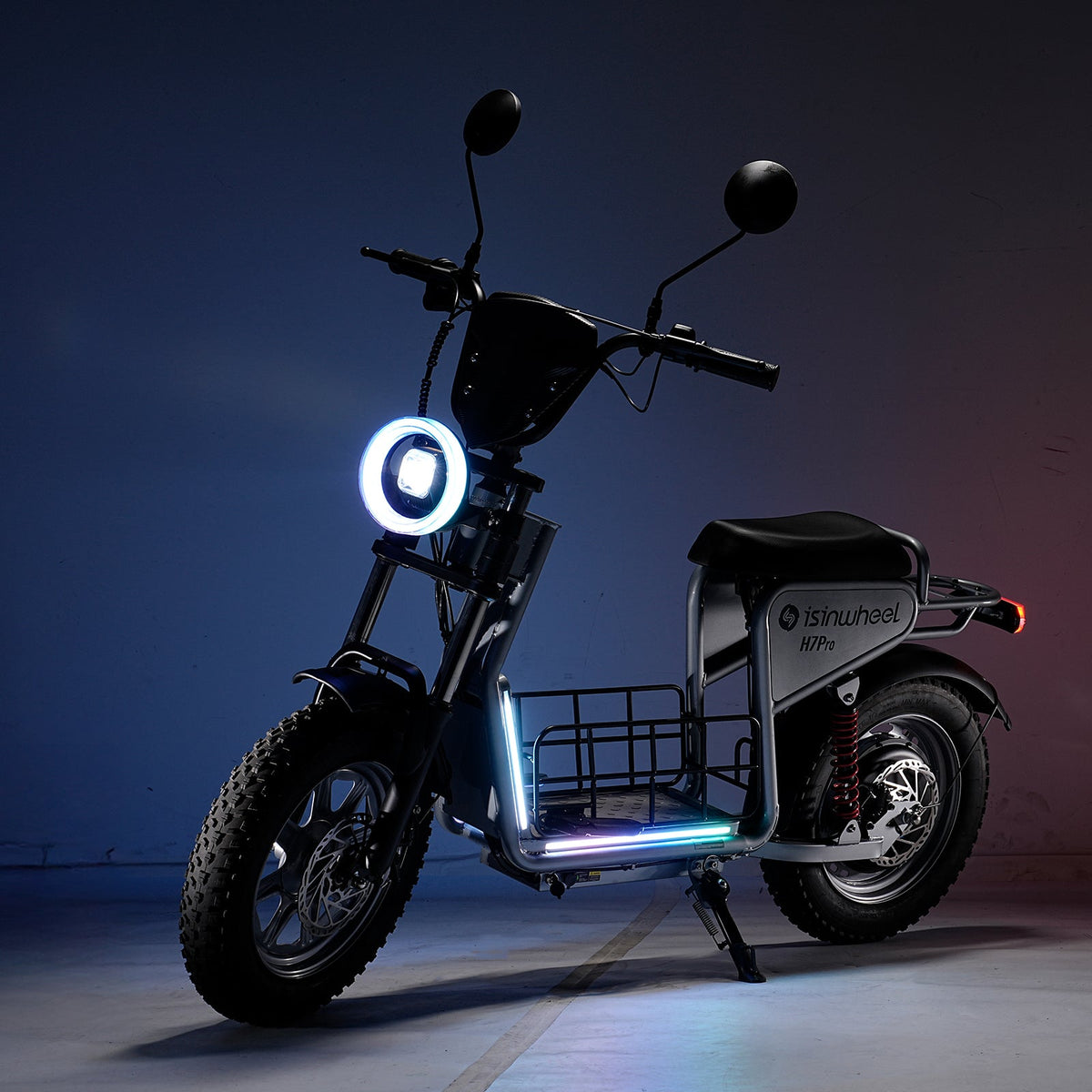 isinwheel H7Pro parked in a dark studio with its circular headlight and deck lighting switched on