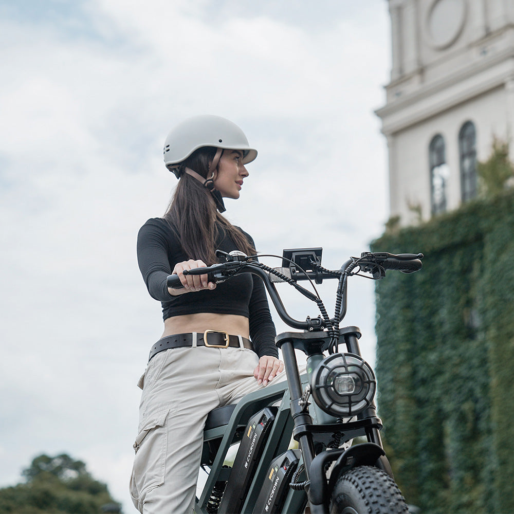 Helmeted rider standing with a mint green CycHunter in town