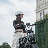 Helmeted rider standing with a mint green CycHunter in town