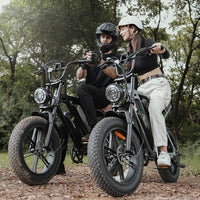 Two riders posing with black and mint green CycHunter bikes in the woods