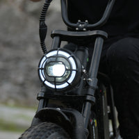 Round CycHunter LED headlight illuminated in daylight
