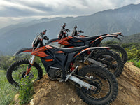 Trailblaze Motors Omega electric dirt bike lineup at a mountain overlook