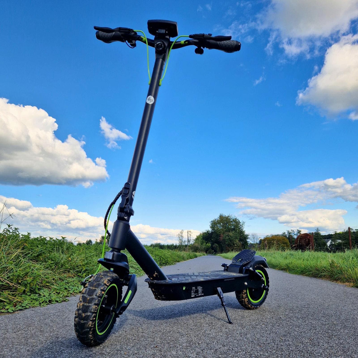 Low front view of the S10Max on pavement beneath a blue sky, showing its front swingarm and pneumatic tire
