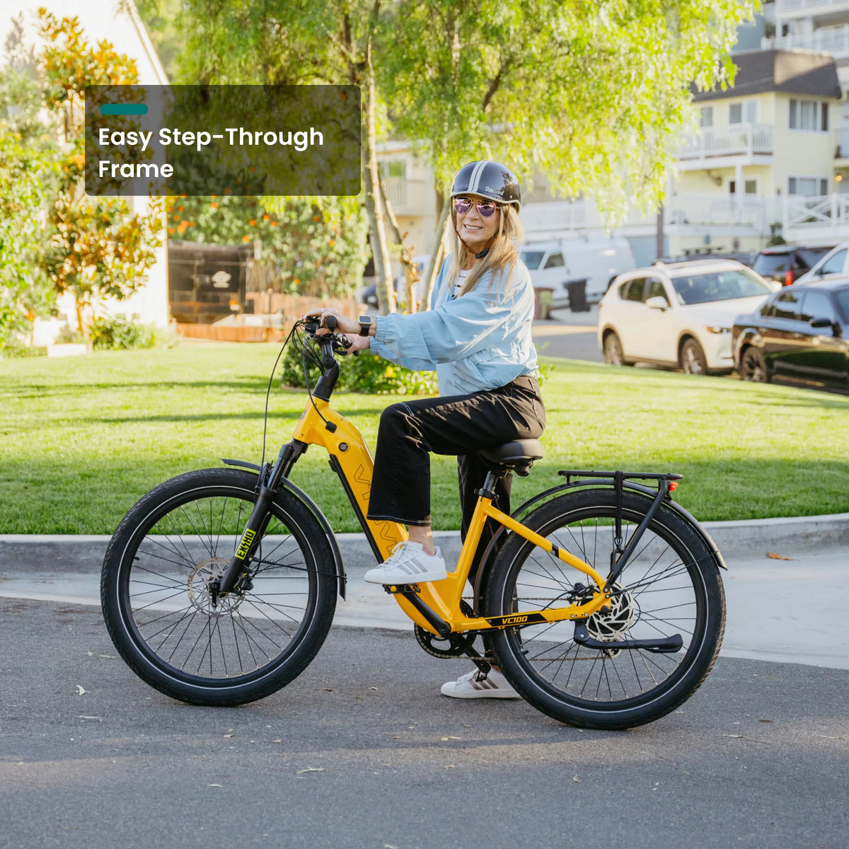 Rider mounting the yellow VTUVIA Zeal LT7 step-through commuter e-bike on a neighborhood street
