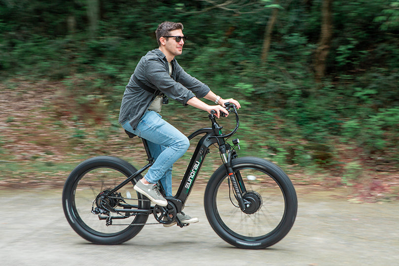 Rider on a Raven EUNORAU FAT-AWD 2.0 fat-tire electric bike on a paved path