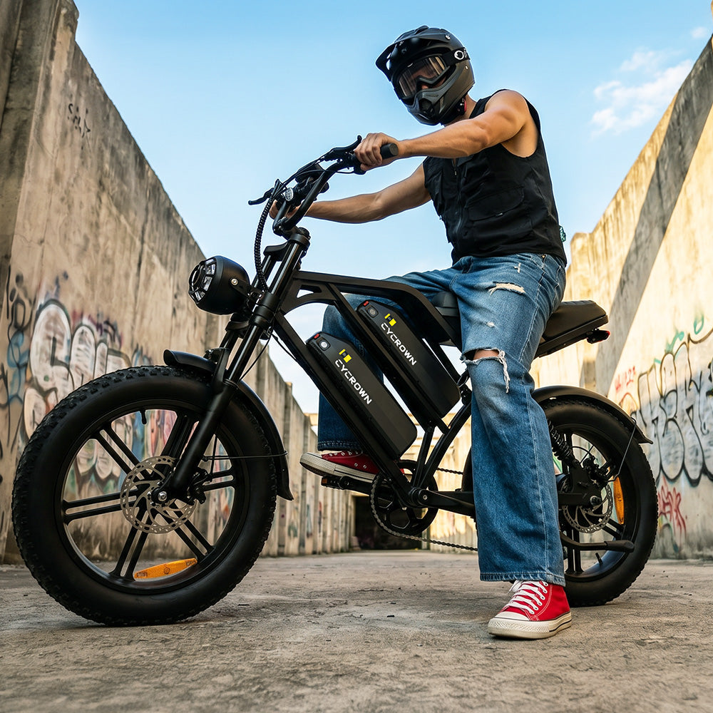 Helmeted rider astride the bike beside an urban concrete wall
