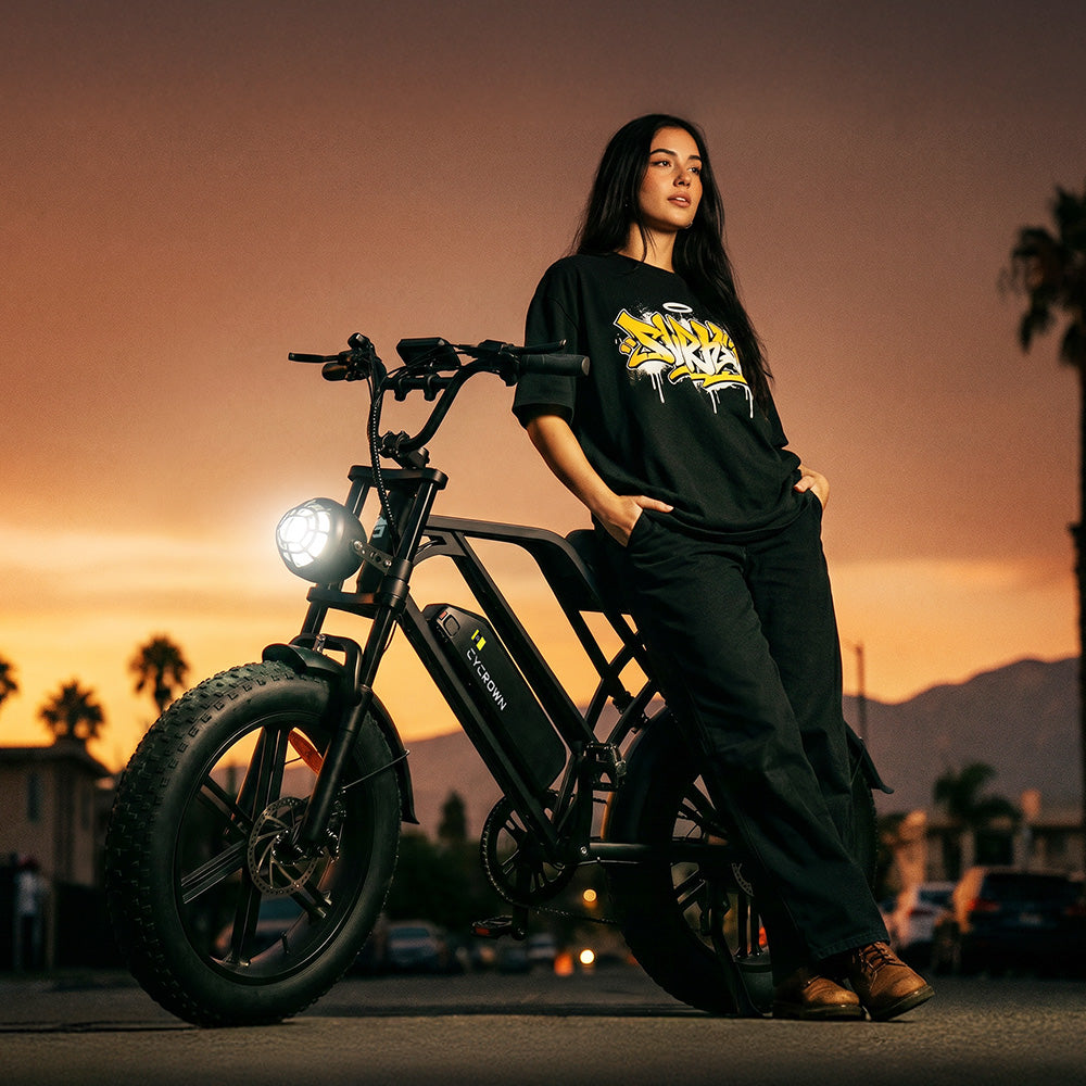 Rider standing beside the headlight-lit bike at sunset