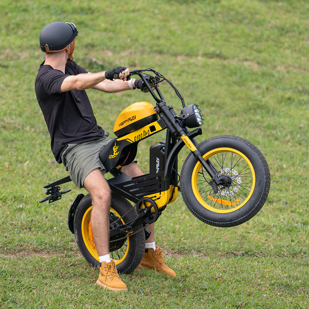 Side profile of the black HappyRun G100 Pro Tank on a paved private road, showing the moto-cruiser stance and long bench saddle