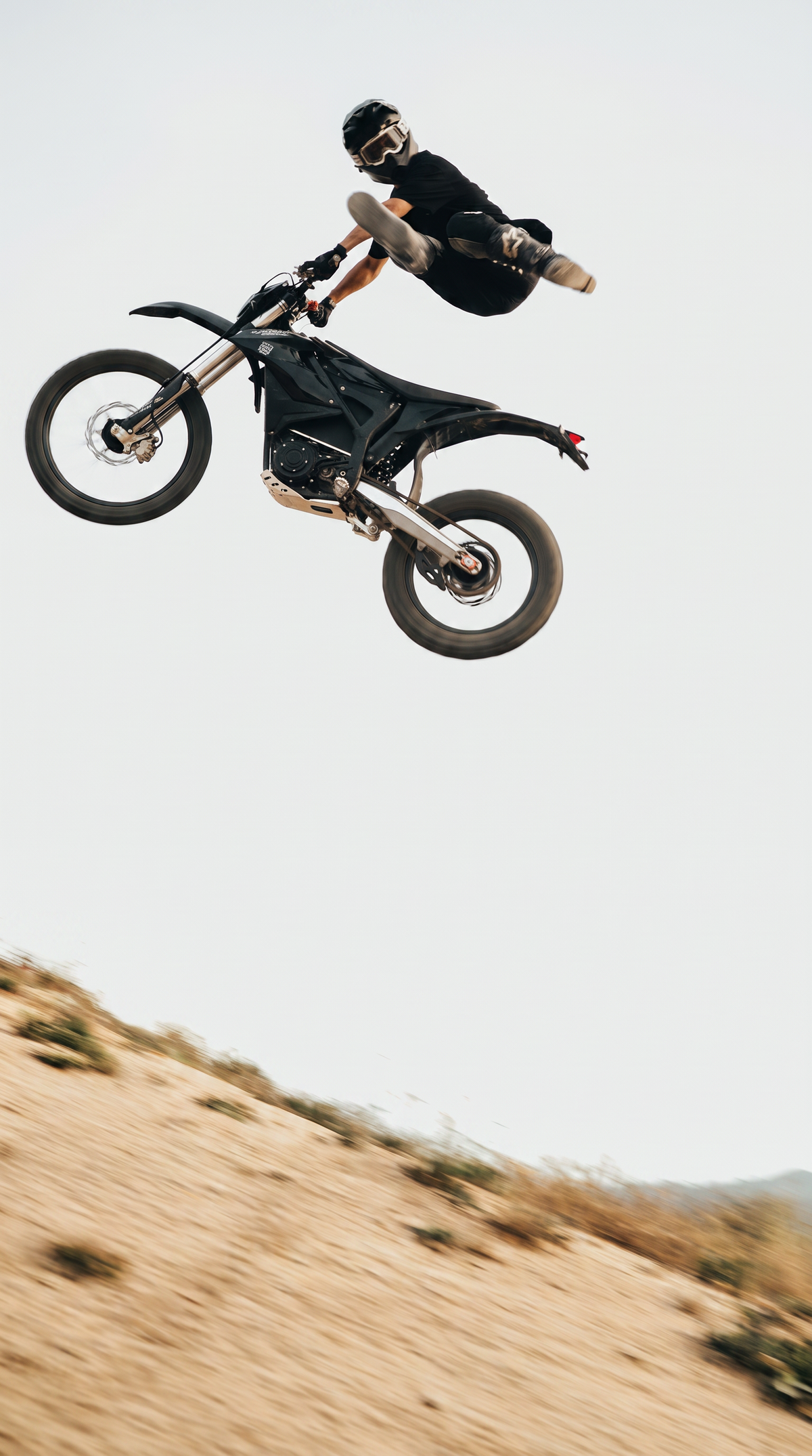 Trailblaze Motors Omega electric dirt bike during a freestyle jump