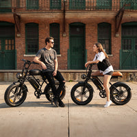 Two riders stopped with CycRun 2.0 e-bikes outside a brick building