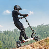Circooter Landturbo Ultra climbing a dirt slope with a rider in full protective gear and forest hills in the background.