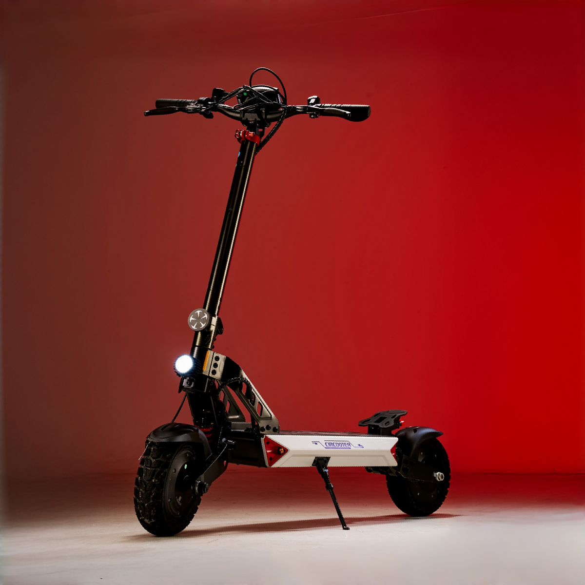 Landturbo Ultra with front headlight on against a red studio backdrop, showing the tall handlebar and off-road tire stance.