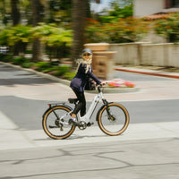 Rider on white VTUVIA Zeal XT8 step-through e-bike in a city setting